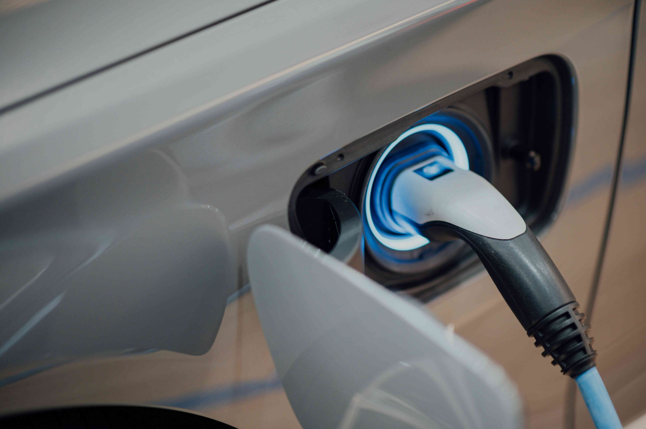 Voiture électrique en charge avec câble branché à une borne de recharge moderne