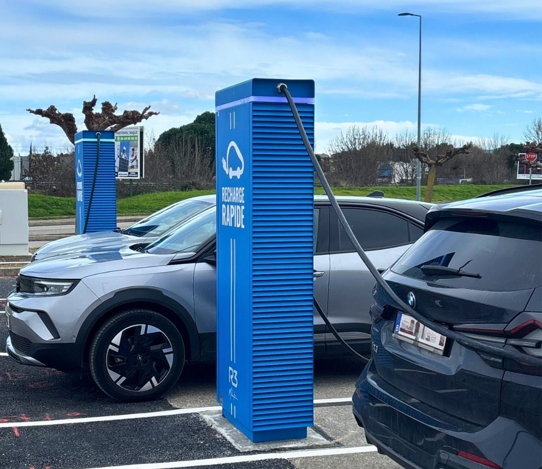 Borne de recharge rapide pour voiture électrique sur parking, avec véhicules branchés en station de recharge moderne