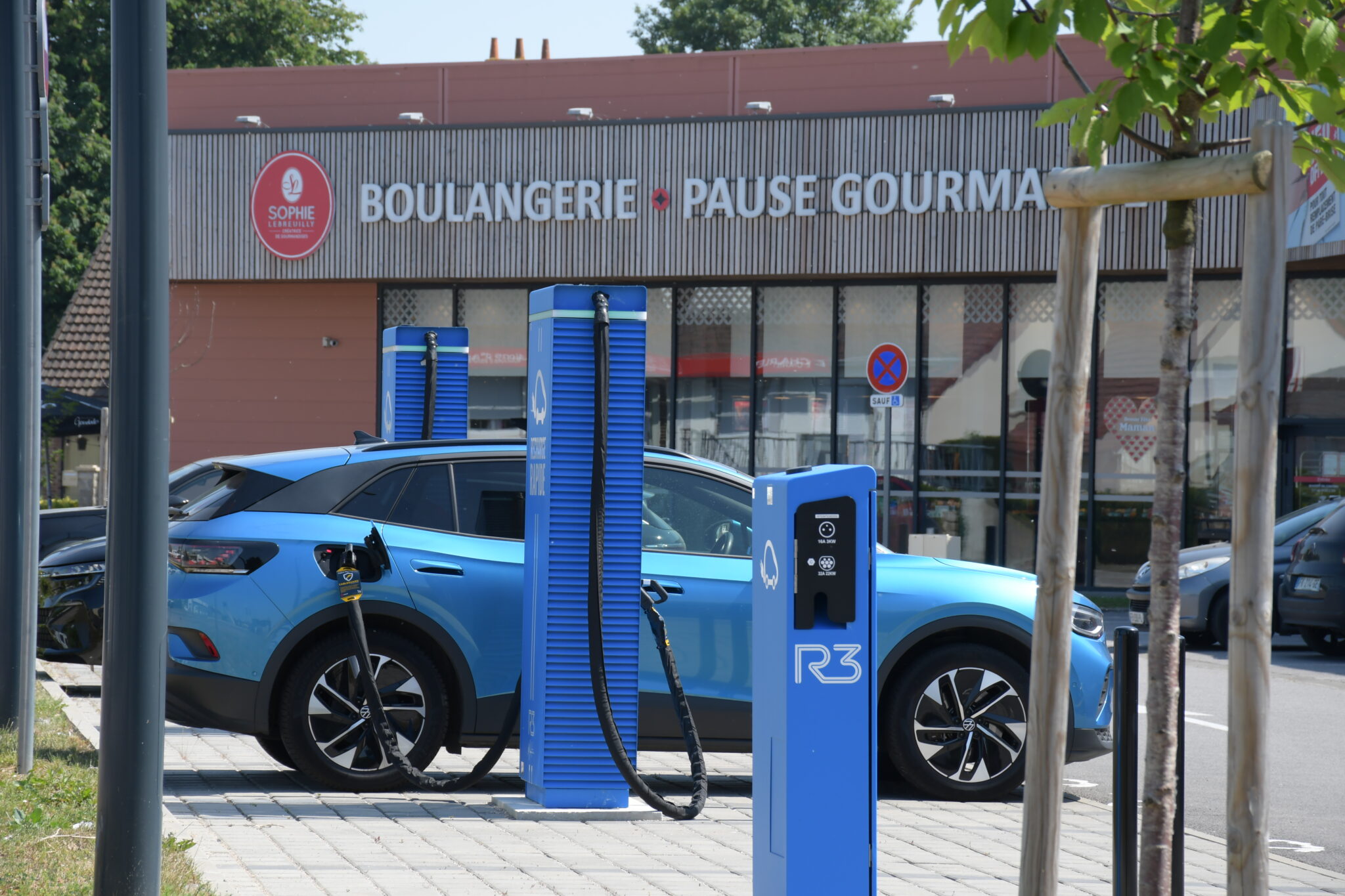 Bornes de recharge rapide R3 sur un parking commercial avec voiture électrique en charge